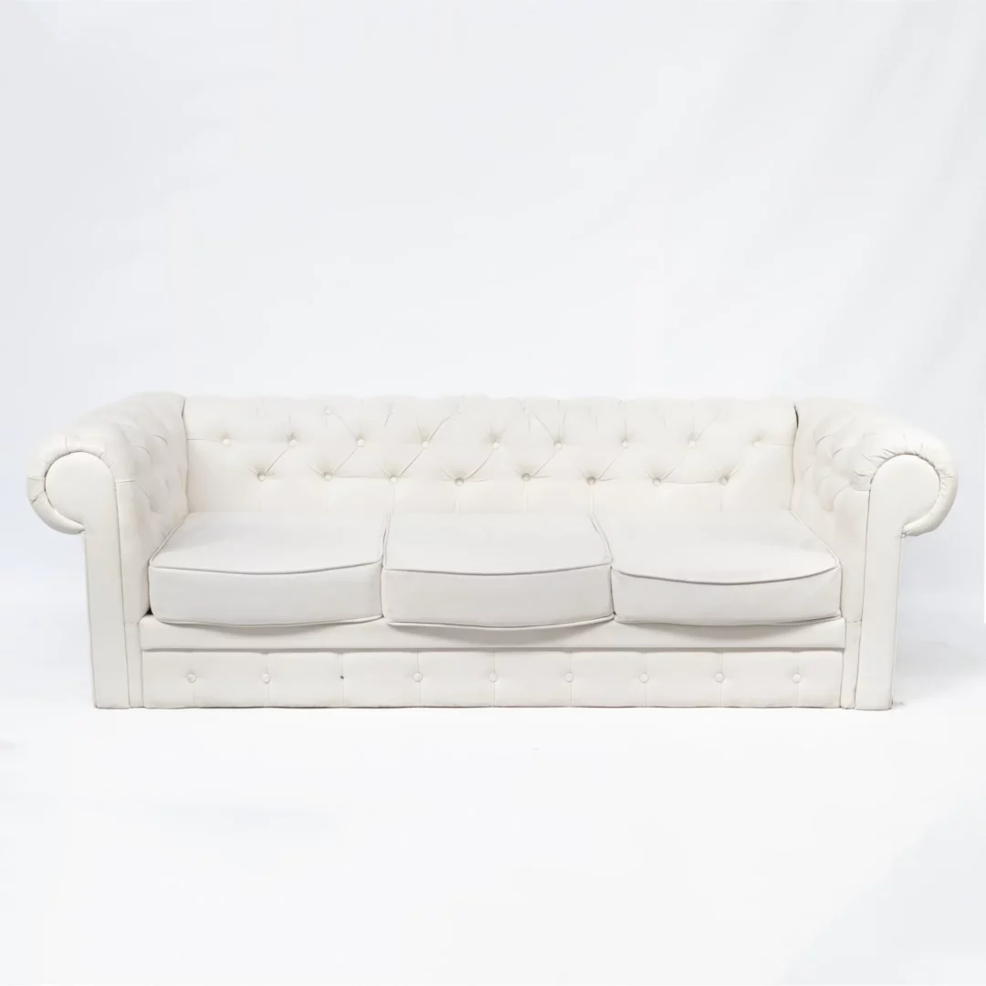 Sofa Chesterfield Biała. Elegancka sofa Chesterfield w białym kolorze, obita eko-skórą, idealna do wynajmu na różne eventy we Wrocławiu. Charakterystyczne pikowanie z guzikami dodaje klasy i luksusu. Trzy oddzielne, miękkie poduszki na siedzisku zapewniają komfort i estetykę. Idealna jako element scenografii na ślub, wesele lub dowolne wydarzenie. Dostępna w wypożyczalni dekoracji RENT4EVENTS, pod markami rent4events.pl oraz rent4weddings.pl. Ta sofa łączy w sobie klasyczny design z eleganckim wykończeniem, tworząc perfekcyjne miejsce do siedzenia na każdym evencie - rent4events.pl wypożycz wrażenia, rent4wedding.pl zachowaj wspomnienia.