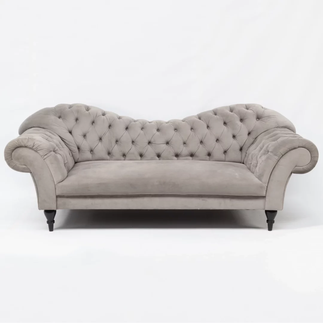 Sofa Chesterfield Szara. Elegancka sofa Chesterfield w szarym kolorze, obita aksamitnym materiałem, idealna do wynajmu na różne eventy we Wrocławiu. Charakterystyczne pikowanie z guzikami oraz szerokie, jednolite siedzisko dodają klasy i luksusu. Zaokrąglone podłokietniki w stylu Chesterfield podkreślają elegancki design. Idealna jako element scenografii na ślub, wesele lub dowolne wydarzenie. Dostępna w wypożyczalni dekoracji RENT4EVENTS, pod markami rent4events.pl oraz rent4weddings.pl. Ta sofa łączy w sobie klasyczny design z eleganckim wykończeniem, tworząc perfekcyjne miejsce do siedzenia na każdym evencie - rent4events.pl wypożycz wrażenia, rent4wedding.pl zachowaj wspomnienia.