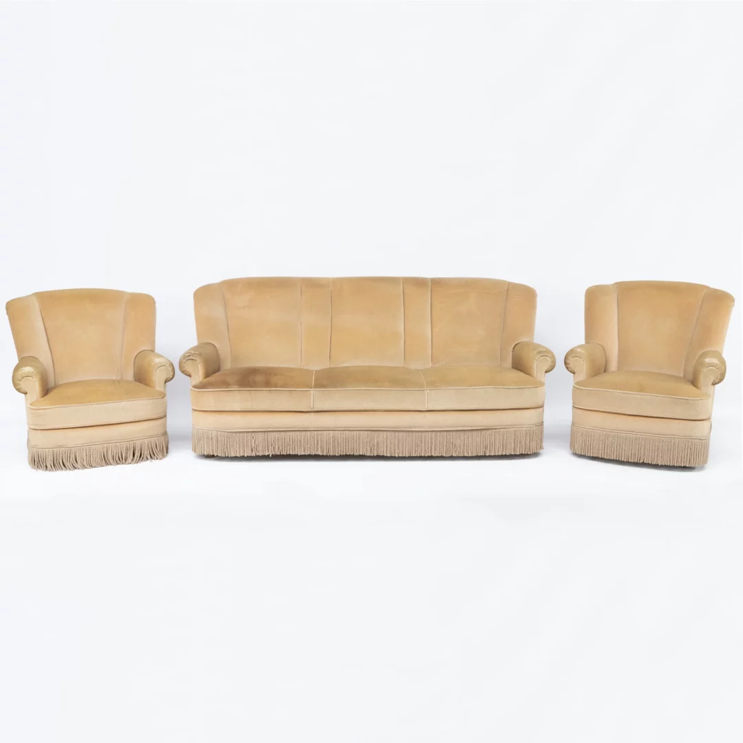 Sofa Retro z Frędzlami i dwa Fotele Retro z Frędzlami. Elegancki zestaw wypoczynkowy w stylu retro, składający się z beżowej sofy i dwóch foteli, ozdobionych kremowymi frędzlami na dolnej krawędzi. Idealny do wynajmu na różne eventy we Wrocławiu i okolicach. Sofa posiada wysokie oparcie podzielone na trzy segmenty, szerokie siedzisko oraz zaokrąglone podłokietniki, co dodaje komfortu. Fotele mają podobny design, z wysokim oparciem i zaokrąglonymi podłokietnikami. Unikalny styl sprawia, że zestaw doskonale nadaje się jako element scenografii lub do przytulnych stref chillout na ślub, wesele lub dowolne inne wydarzenie. Dostępny w wypożyczalni dekoracji RENT4EVENTS, ten zestaw łączy w sobie komfort i retro styl, tworząc perfekcyjne miejsce do siedzenia na każdym evencie - rent4events.pl wypożycz wrażenia, rent4wedding.pl zachowaj wspomnienia.